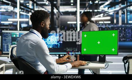 System administrator uses node tree AI software on a green screen computer for data center analysis. Stock Photo