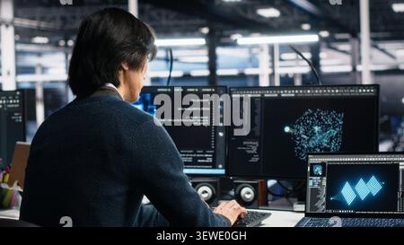 System administrator uses deep learning tools on a digital device in a server room to improve AI operations and system efficiency. Stock Photo