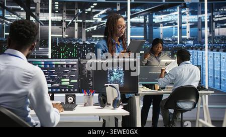 Engineer uses a computer workstation in a server farm to categorize unstructured data with node tree systems. Stock Photo