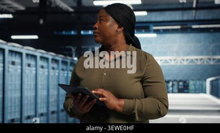 Data center engineer manages software updates in a server room to keep data center systems stable. Stock Photo