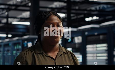 Data center engineer conducts security audits in a data center to reduce cyber threats and compliance errors. Stock Photo