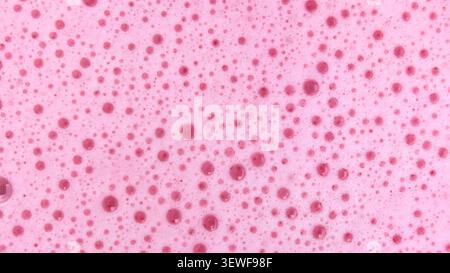 pink soap foam texture featuring soft bubbles and a clean, fresh appearance. This abstract background is ideal for cosmetic branding, skincare package Stock Photo