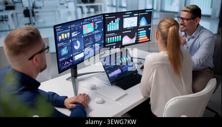 Team Of Financial Analysts Working Together On Business Dashboard Metrics. Stock Photo