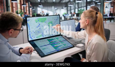 Diverse Real Estate Team Meets, Using Laptops And Maps Together. Stock Photo