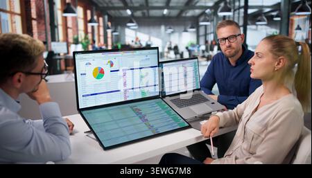 Medical Coder Team Works Together Reviewing Billing Codes On Laptops. Stock Photo