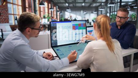 Three Data Analysts Working Together On Financial Dashboard Insights. Stock Photo