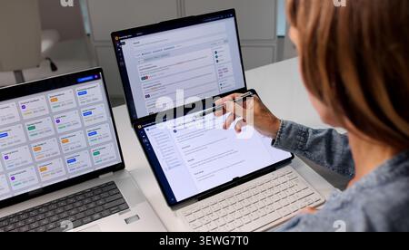 Mature Woman Reviews AI-powered Document Retrieval System On Laptop Screen. Stock Photo