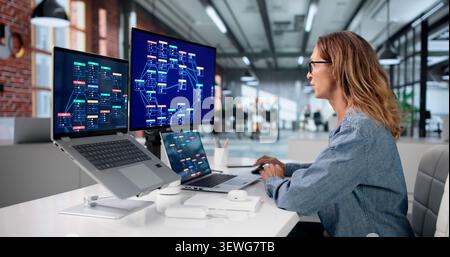 Mature Woman Builds Workflows Using Low Code Platform On Laptop. Stock Photo