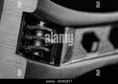Macro view shows adjustable wrench head, toothed worm gear, and open jaw against dark background, emphasizing rugged steel texture and mechanical precision Stock Photo