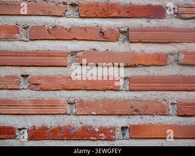 Red brick wall displaying textured surface with rough mortar joints Stock Photo