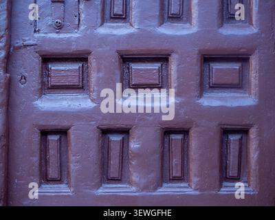Weathered texture of a traditional wooden building door panel with decorative patterns Stock Photo