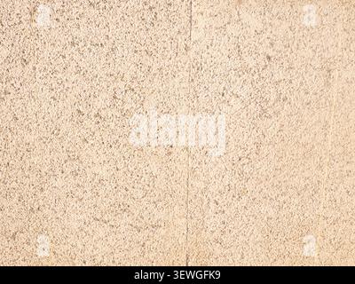 Rough beige concrete wall surface showing a textured background Stock Photo