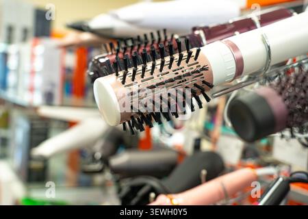 A Colorful Array of Hair Styling Tools Displayed on Shelves in a Beauty Supply Store Featuring Brushes, Curling Irons, and Hair Dryers Stock Photo