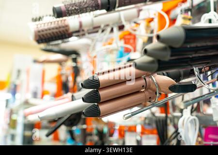 A Display of Various Hair Styling Tools Including Curling Irons, Straighteners, and Hairdryers in a Hair Salon Equipment Shop Stock Photo