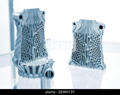 Objects heat exchanger with conformal cooling channels and filter or heat exchange element printed on 3D printer. Models printed on 3D printer from metal powder. Selective Laser Melting. SLM. Additive Stock Photo