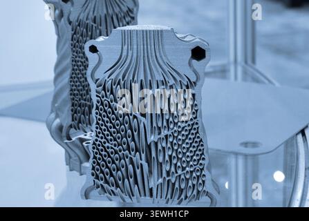 Objects heat exchanger with conformal cooling channels and filter or heat exchange element printed on 3D printer. Models printed on 3D printer from metal powder. Selective Laser Melting. SLM. Additive Stock Photo
