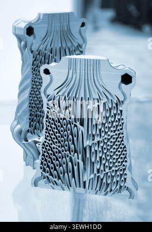 Objects heat exchanger with conformal cooling channels and filter or heat exchange element printed on 3D printer. Models printed on 3D printer from metal powder. Selective Laser Melting. SLM. Additive Stock Photo