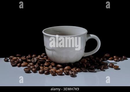 A white porcelain coffee cup surrounded by coffee beans Stock Photo