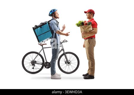 Bicycle delivery man talking to a grocery courier and holding a paper bag isolated on white background Stock Photo