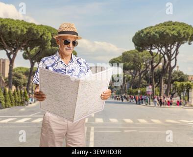 Elderly tourist man looking at a map outdoors on a street in Rome, Italy Stock Photo