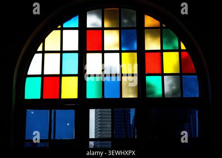 Vibrant Arched Stained Glass Window with Colorful Geometric Grid Pattern Stock Photo