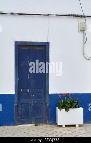 Charming details of traditional Canarian street architecture featuring a colorful blue and white wall with potted flowers, providing excellent copy sp Stock Photo
