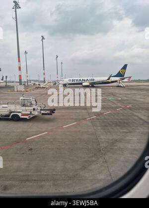 Ryanair airplane parked on airport apron under dramatic cloudy sky Stock Photo