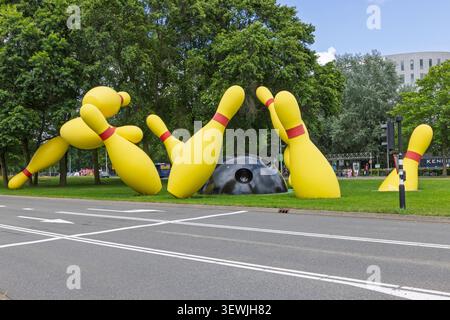 Eindhoven, Netherlands - June 13, 2026: The iconic Flying Pins public sculpture featuring massive yellow bowling pins and a black ball on a grass lawn Stock Photo