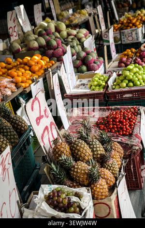 This eye-level, slightly tilted perspective shot shows a wide array of fresh produce arranged in crates and boxes on market stalls. In the foreground, Stock Photo