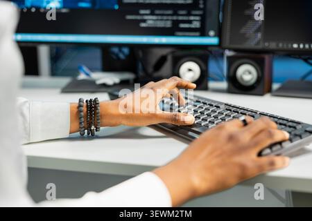 Computer scientist works with desktop computer in a data center to support data processing, analytics, and storage infrastructure. Stock Photo
