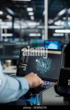 Technician uses an AI language model assistant in a server farm to handle infrastructure maintenance. Stock Photo