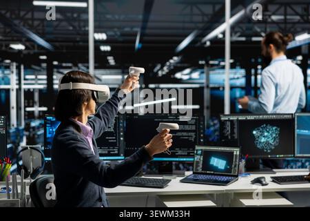 Data center programmer uses a VR headset in a data center to manage AI systems, train neural networks, and configure hardware. Stock Photo
