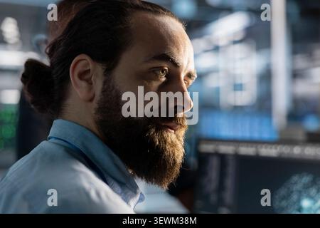 System administrator reviews artificial intelligence systems and machine learning processes inside a data center. Stock Photo