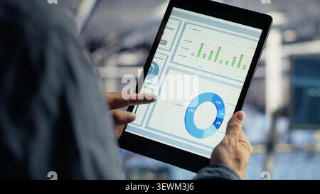 Data center worker uses a tablet to run diagnostics, update servers and check infrastructure performance. Stock Photo