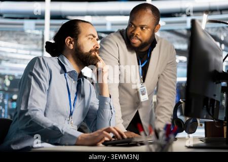 Data center manager reviews artificial intelligence systems and machine learning processes inside a data center. Stock Photo