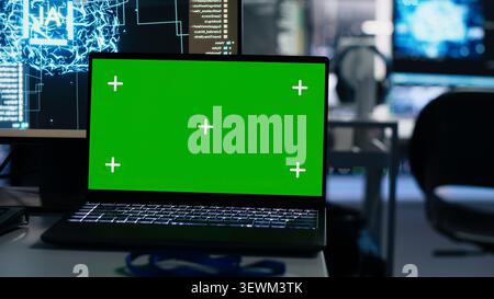 IT specialist works with a laptop in a server hub to support artificial intelligence systems. Stock Photo