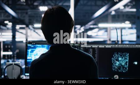 System administrator reviews artificial intelligence systems and machine learning processes inside a data center. Stock Photo