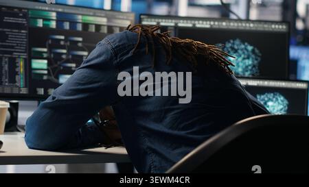 Data center engineer reacts to malfunctioning software and technical errors inside a server room. Stock Photo