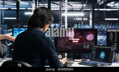 Data center engineering team responds to a warning alert on a digital device while troubleshooting server room systems. Stock Photo