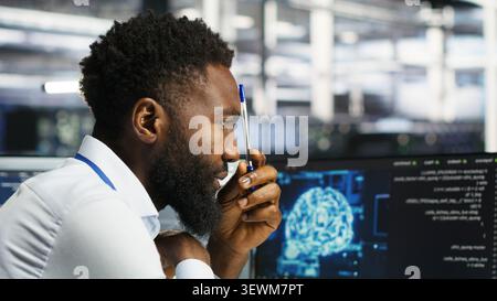 Programmer uses neural network node tree software to analyze infrastructure in a data center. Stock Photo