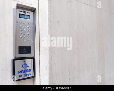 Disabled accessible push button buzzer for assistance sign at building entrance  Stock Photo