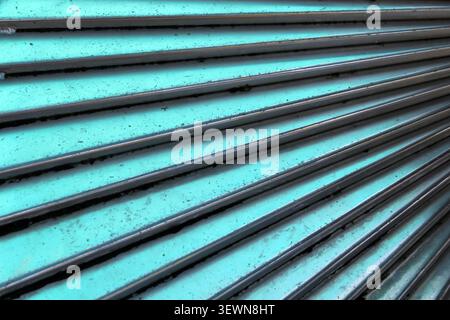 Close-up abstract view of a solid piece of turquoise corrugated metal forming a repetitive linear pattern Stock Photo