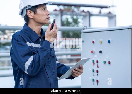 Mechanic or maintenance or electrical engineer checking main electrical control systems industrial plant. Utility fore man daily check power systems i Stock Photo