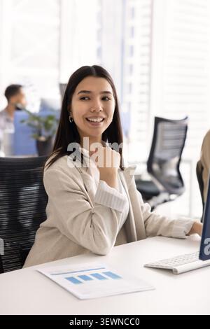 Happy young woman working at modern office desk Stock Photo