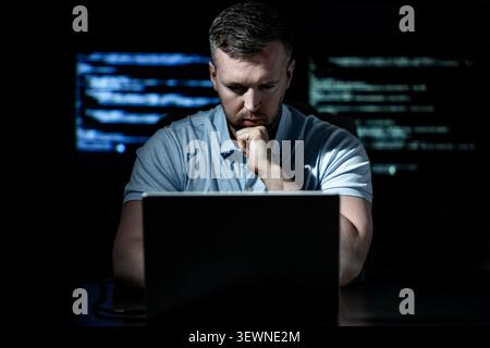 Hacker works on programming and coding. Hacker analyzes digital system vulnerabilities. Hacker monitors secure network infrastructure. Hacker attempts Stock Photo