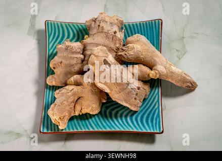 Ginger roots ready for culinary use and promoting wellness on a decorative plate Stock Photo