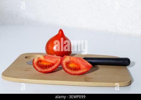 Sliced ​​tomatoes showcase their juicy texture and rich color. They lie on a wooden board or white plate, creating a vibrant contrast. Stock Photo