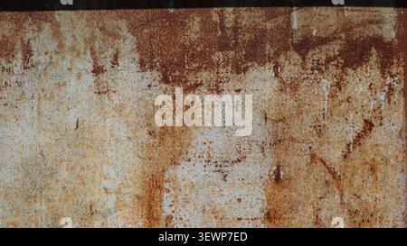 flat texture of old iron, covered in a thick layer of oxidation. Red, brick, and brown streaks are visible on the gray-white base. Stock Photo