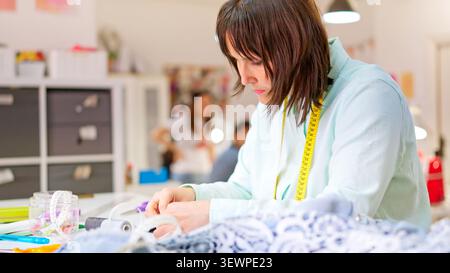Tailor working on garment in creative sewing workshop Stock Photo