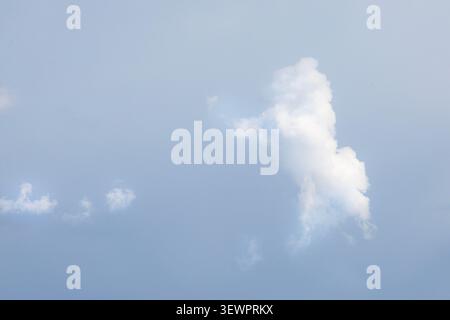 Bright white cumulus cloud floating in clear blue summer sky with copy space Stock Photo